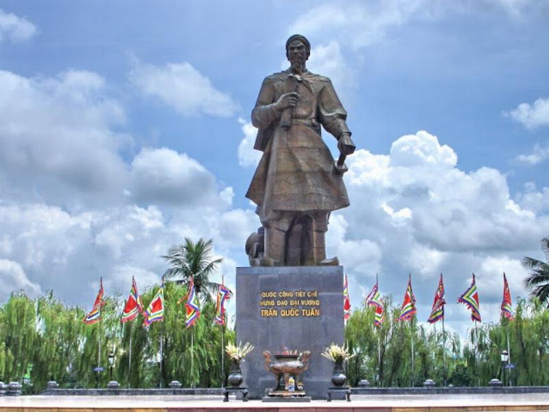 Một hình ảnh minh họa kết hợp giữa bát phở bò Nam Định hấp dẫn và hình ảnh quần thể di tích đền Trần hoặc chùa Tháp Phổ Minh, thể hiện sự kết nối giữa ẩm thực và văn hóa lịch sử của Nam Định